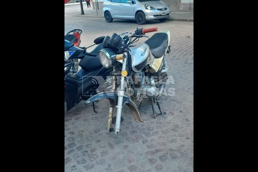 Moto a la que le robaron la rueda en el centro.